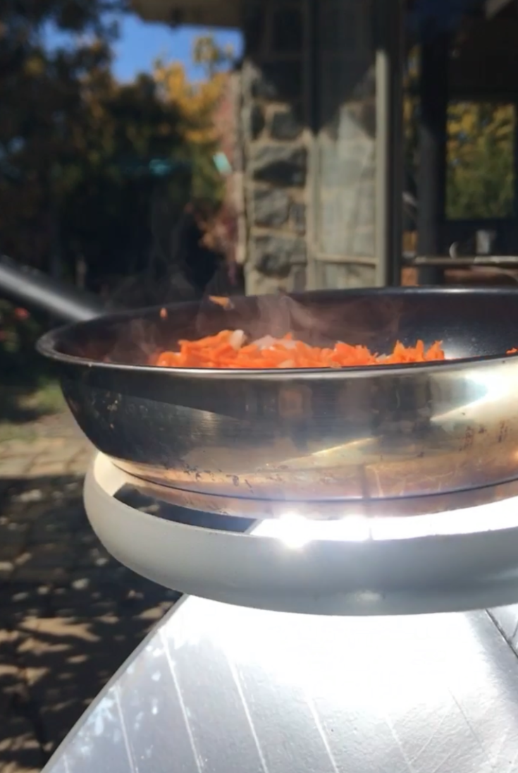 Verduras sofriéndose en la cocina solar parabólica