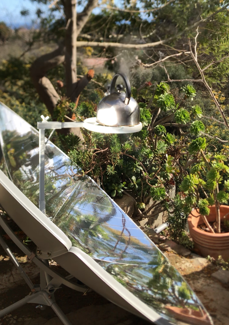 Una tetera con agua hirviendo en la cocina solar parabólica